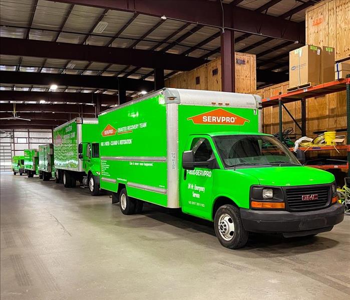 5 Green SERVPRO trucks in a warehouse in Atlanta waiting to be dispatched to a water restoration project.